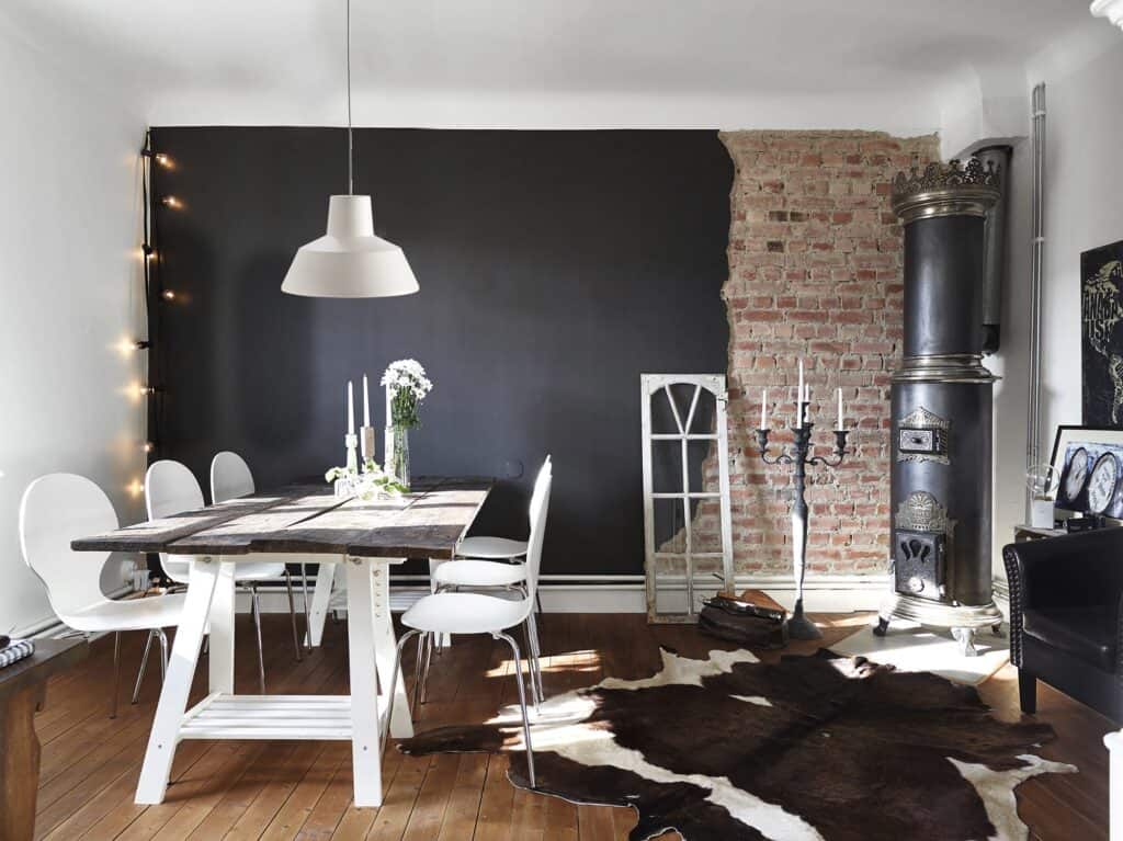 Rústica casa de campo con comedor moderno y chimenea de leña en interior elegante y acogedor.