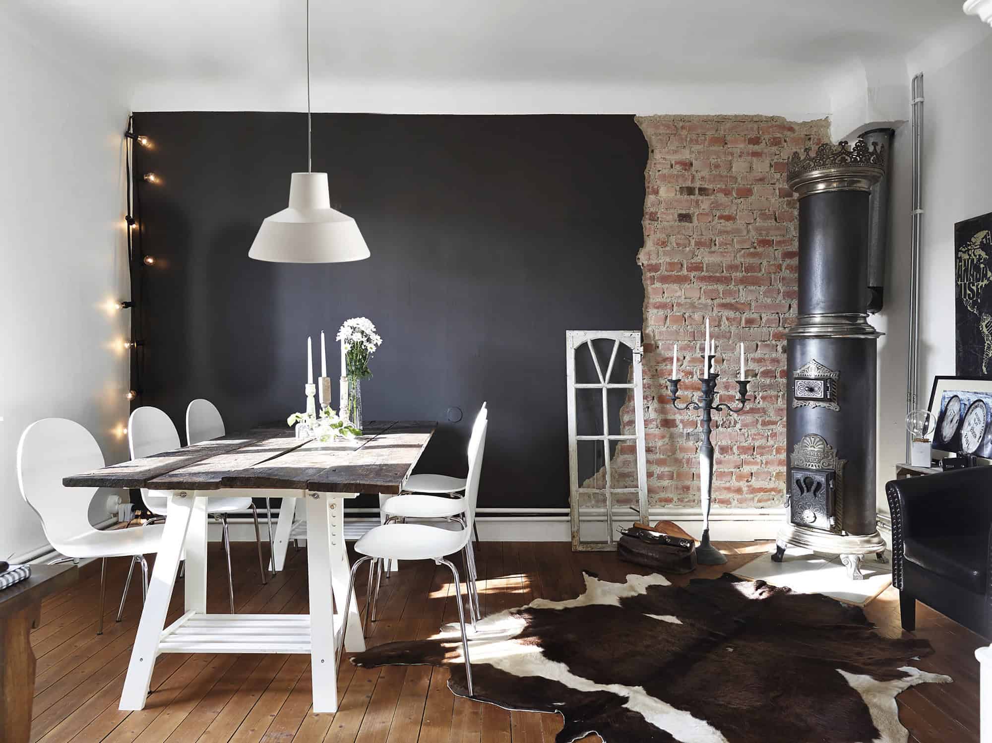 Rústica casa de campo con comedor moderno y chimenea de leña en interior elegante y acogedor.