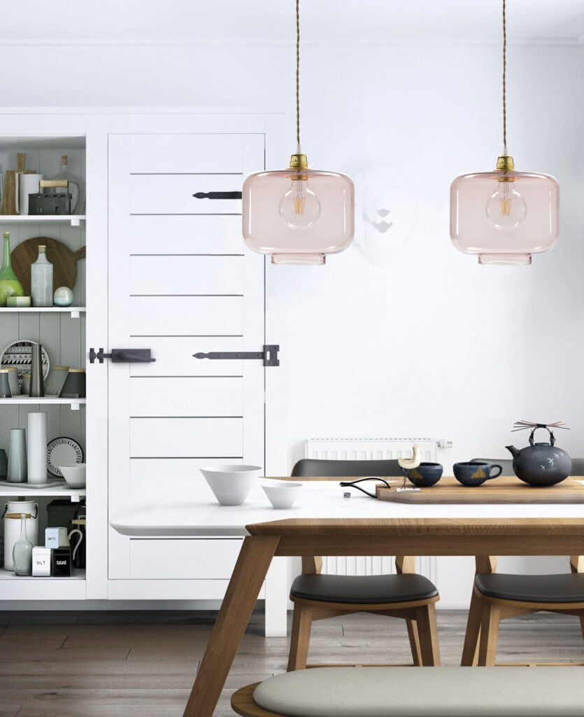 Lámparas de vidrio rosa en comedor moderno y minimalista.