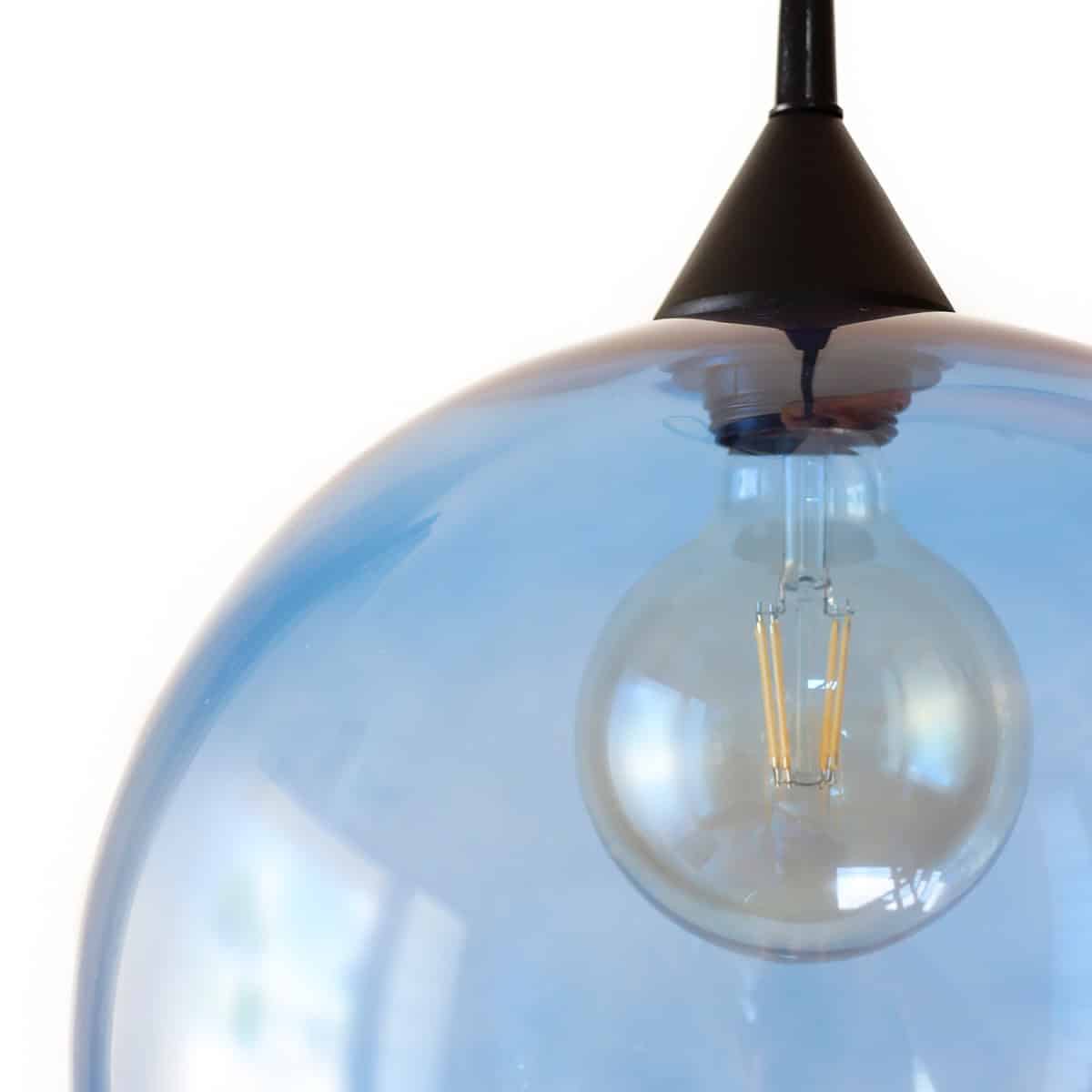 Iluminación moderna con lámpara colgante de vidrio y bombilla de filamentos.